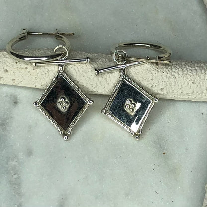 Pair of silver diamond shaped earrings